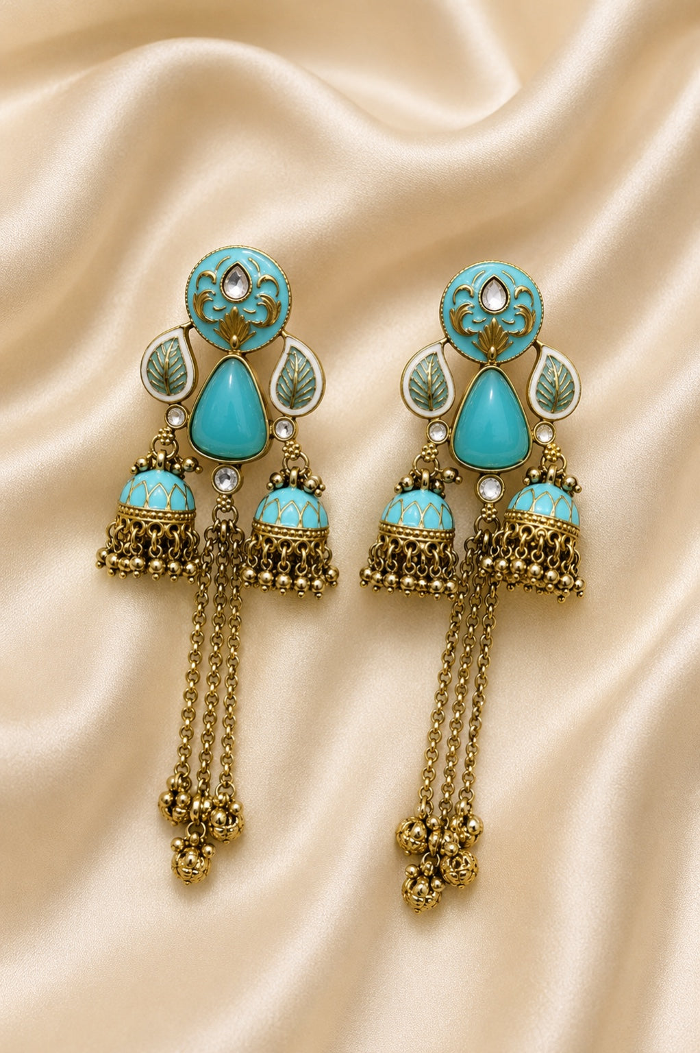 Azure Royale Twin Jhumka Earrings in antique gold finish with turquoise enamel, crystal accents and chain tassels by Rich Rose Jewellery.